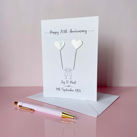 70th anniversary card with silver mirror card hearts and couple illustration on a pink background