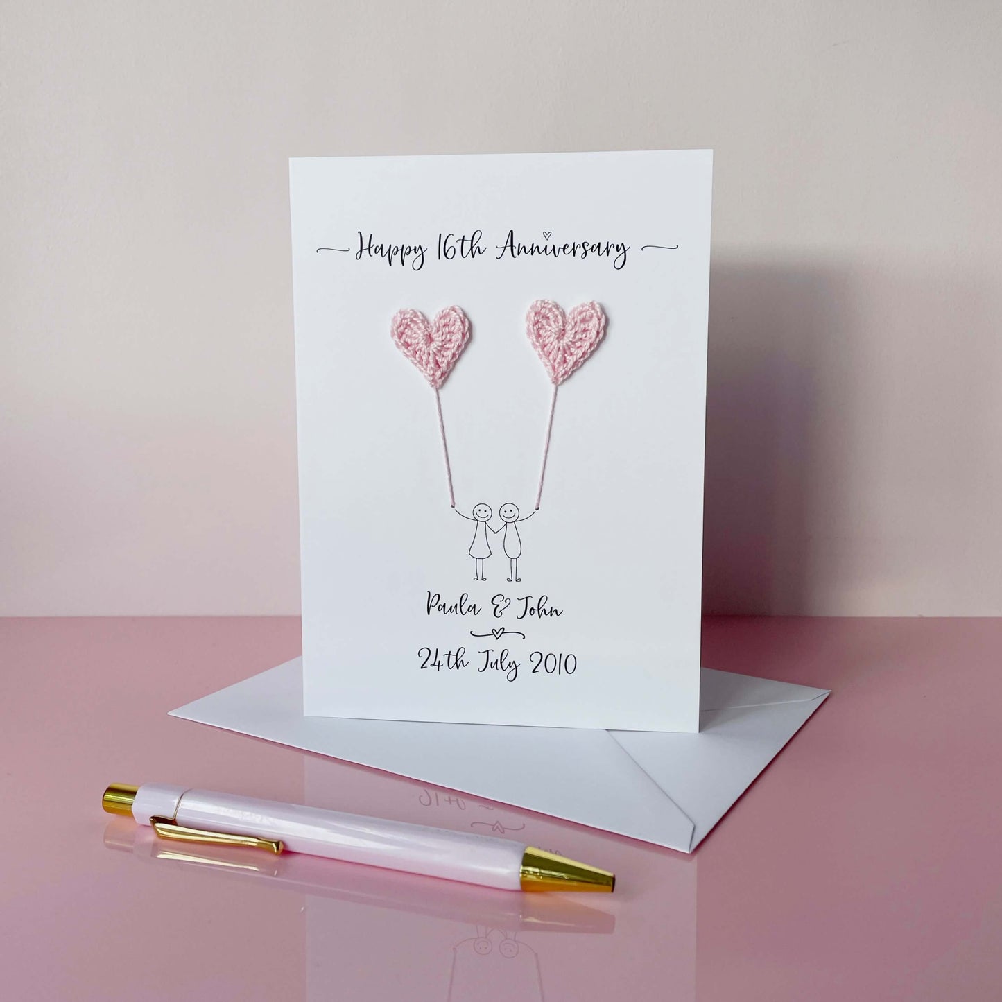 personalised 16th anniversary card with pale pink crochet heart balloons. The couples names and wedding date is printed on the card. 