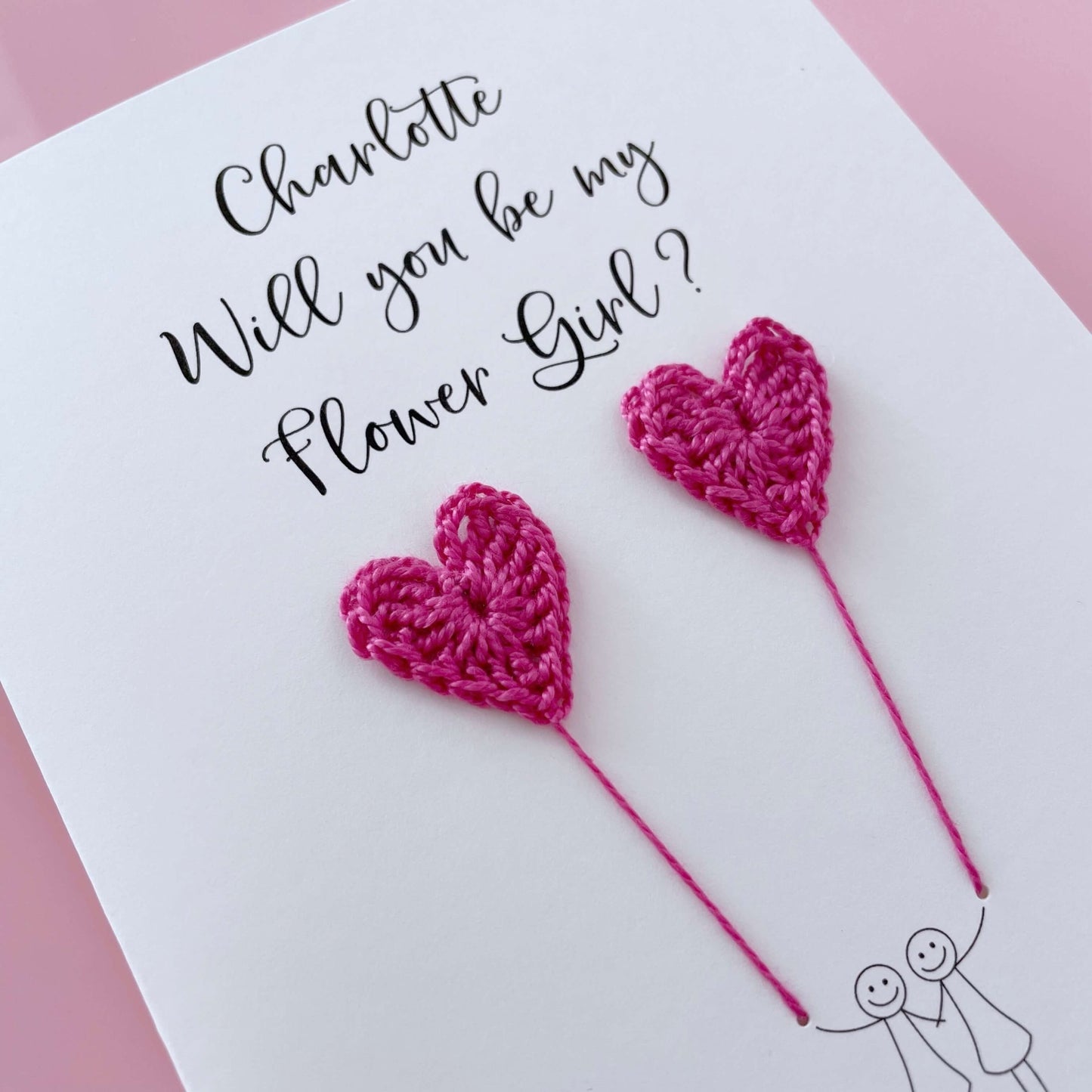 Card with bright pink crochet hearts. test reads 'Charlotte Will you be my Flower Girl? 