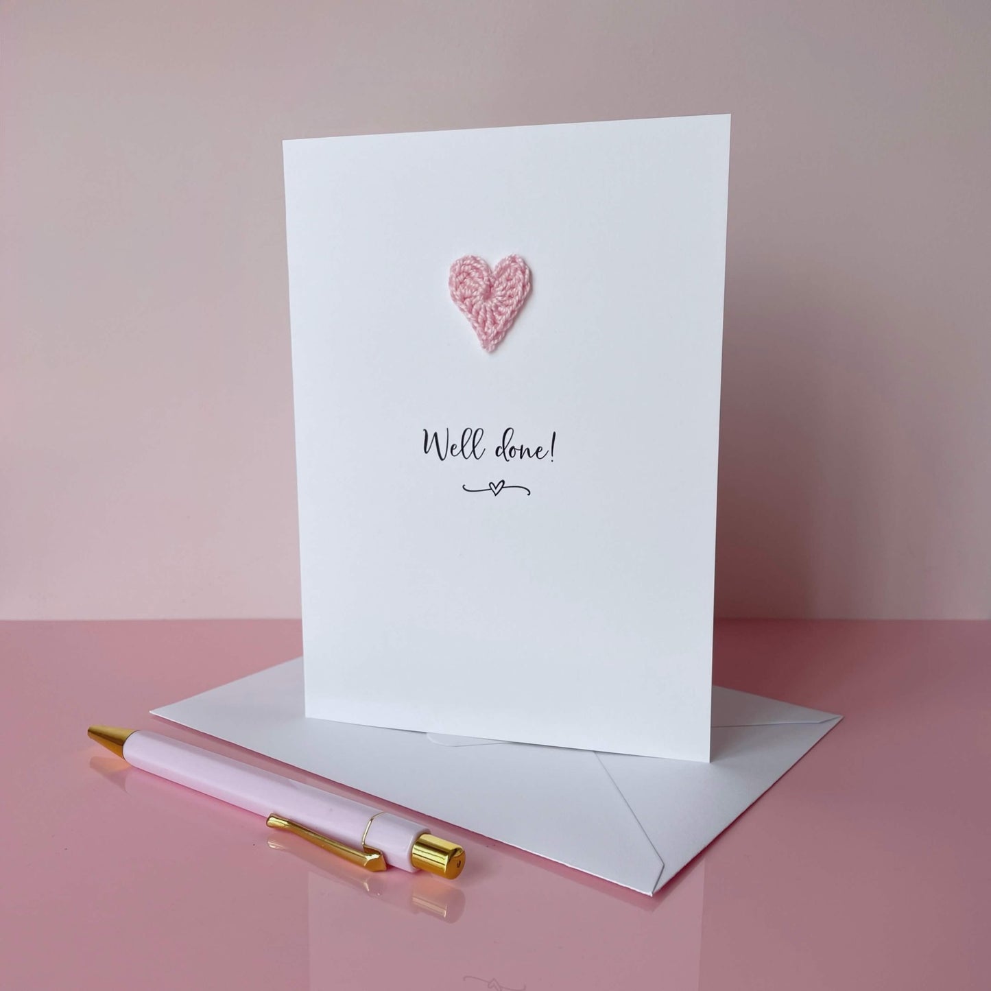 Greeting card with pink heart and 'Well done!' text on a pink background