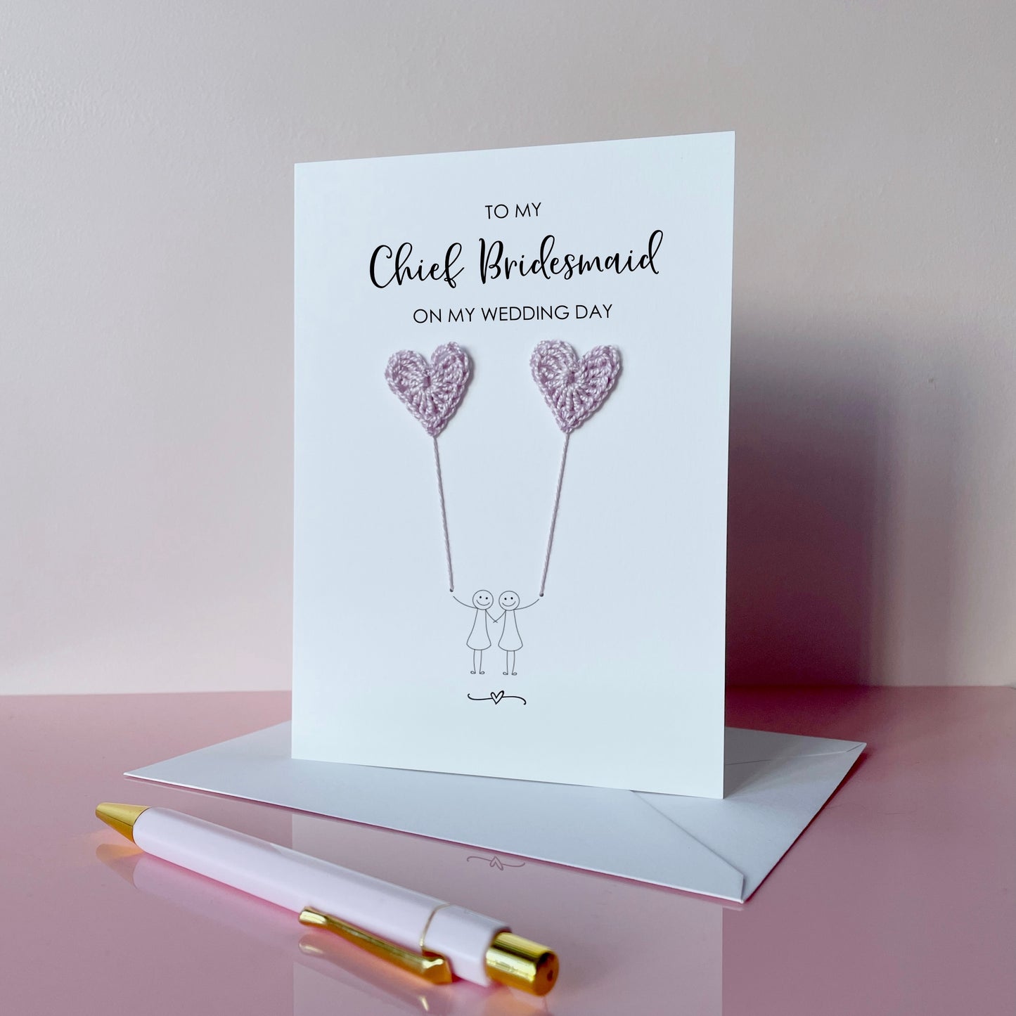 Greeting card with lilac crochet heart balloons and text on a pink surface. The text at the top of the cad reads 'To my Chief Bridesmaid on my wedding day' 