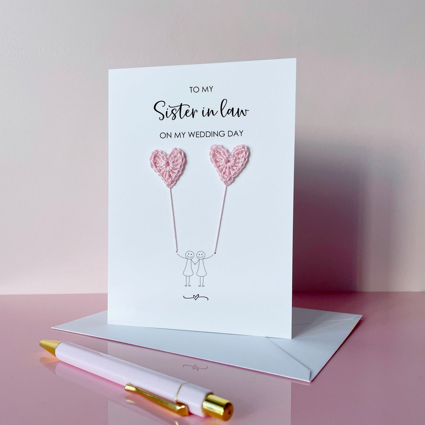 Greeting card with pale pink crochet heart balloons. The text at the top of the card reads 'To my Sister in law on my wedding day' 
